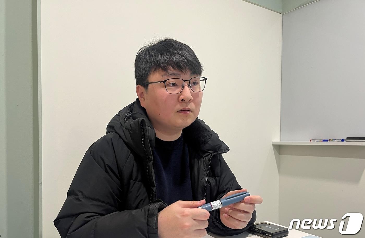 본문 이미지 - 박경준씨(34)가 지난 1월16일 서울 서초구의 한 공유오피스 회의실에서  <뉴스1>과 인터뷰하고 있다. 9살 때 처음 1형 당뇨 진단을 받은 경준씨는 평소 자신이 쓰는 인슐린 주사기를 손에 들고 있다. / 뉴스1 ⓒ News1 박혜연 기자