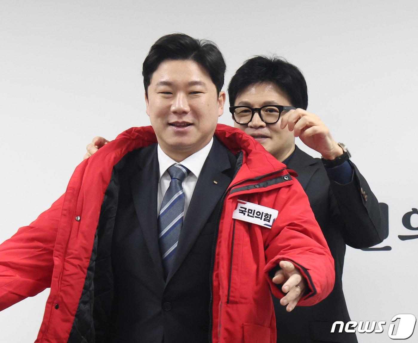 본문 이미지 - 한동훈 국민의힘 비상대책위원장이 5일 서울 여의도 국회 국민의힘 당사에서 열린 인재 영입 환영식에서 진종오 전 국가대표 사격선수에게 국민의힘 옷을 선물하고 있다. 2024.2.5/뉴스1 ⓒ News1 송원영 기자
