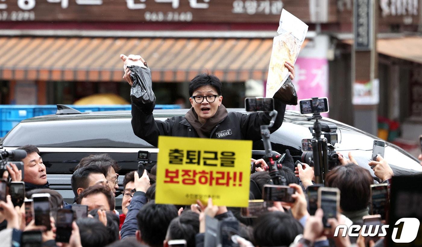본문 이미지 - 한동훈 국민의힘 비상대책위원장이 설 명절 연휴를 나흘 앞둔 5일 서울 동대문구 청량리 청과물시장·경동시장을 방문해 구매한 상품을 들어보이며 시민들과 인사를 나누고 있다. (공동취재) 2024.2.5/뉴스1 ⓒ News1 임세영 기자