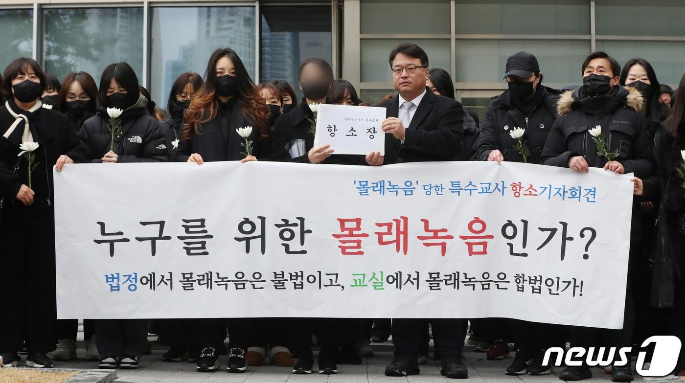 본문 이미지 - 웹툰 작가 주호민씨 아들(10)을 학대한 혐의로 1심에서 벌금 200만원 선고유예를 받은 특수교사 A씨와 김기윤 경기도교육감 고문변호사가 6일 오전 경기 수원시 영통구 수원지방법원에서 기자회견을 하기 전 항소장을 들고 있다. 2024.2.6/뉴스1 ⓒ News1 김영운 기자