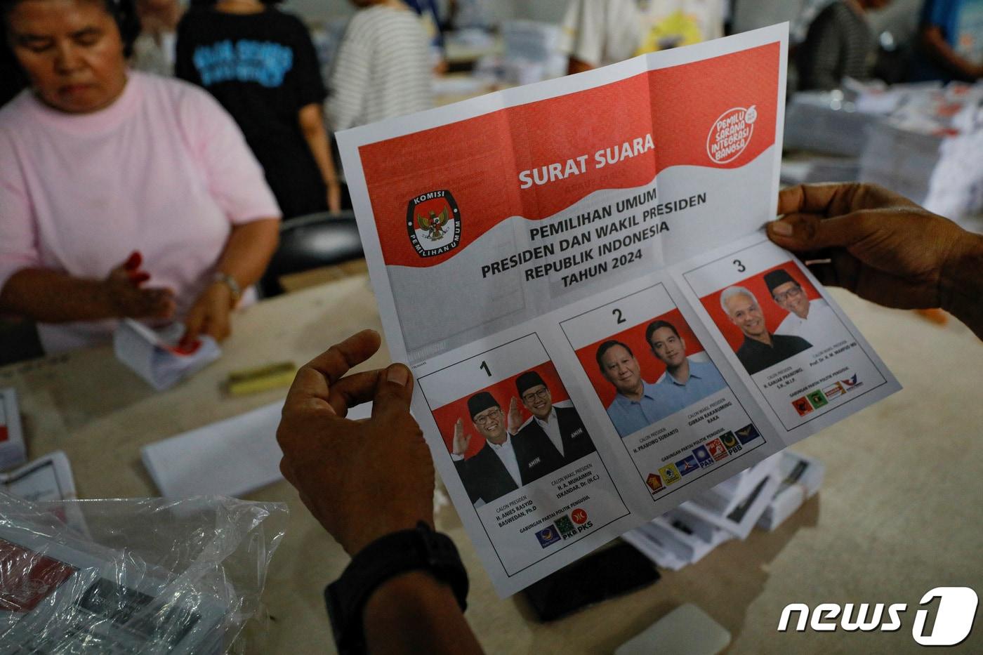 본문 이미지 - 8일(현지시간) 인도네시아 대선을 앞두고 수도 자카르타에서 선거관리위원회 직원이 각 후보들의 얼굴과 이름이 담긴 투표용지를 접고 있다. 인도네시아 대선은 오는 2월14일 치러진다. 2024.01.08/ ⓒ 로이터=뉴스1 ⓒ News1 박재하 기자