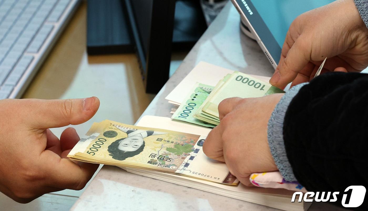 설 명절 연휴를 하루 앞둔 8일 서울 서초구 경부고속도로 만남의 광장에서 운영 중인 하나은행 신권 교환 이동점포에서 은행원이 손님의 구권을 신권으로 교환해 주고 있다. 2024.2.8/뉴스1 ⓒ News1 장수영 기자