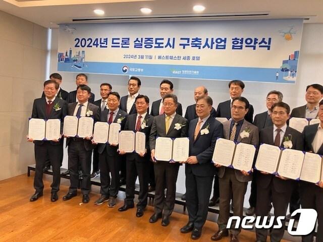 본문 이미지 - 울산시 울주군이 11일 세종특별자치시 베스트웨스턴플러스 세종 토파즈룸에서 국토교통부가 주최하고 항공안전기술원이 주관하는 ‘2024년 드론실증도시 구축사업’ 업무협약을 체결한 가운데 김석명 울주군 부군수를 비롯한 실증도시 17개 지자체 참석자들이 협약식 후 기념촬영을 하고 있다.