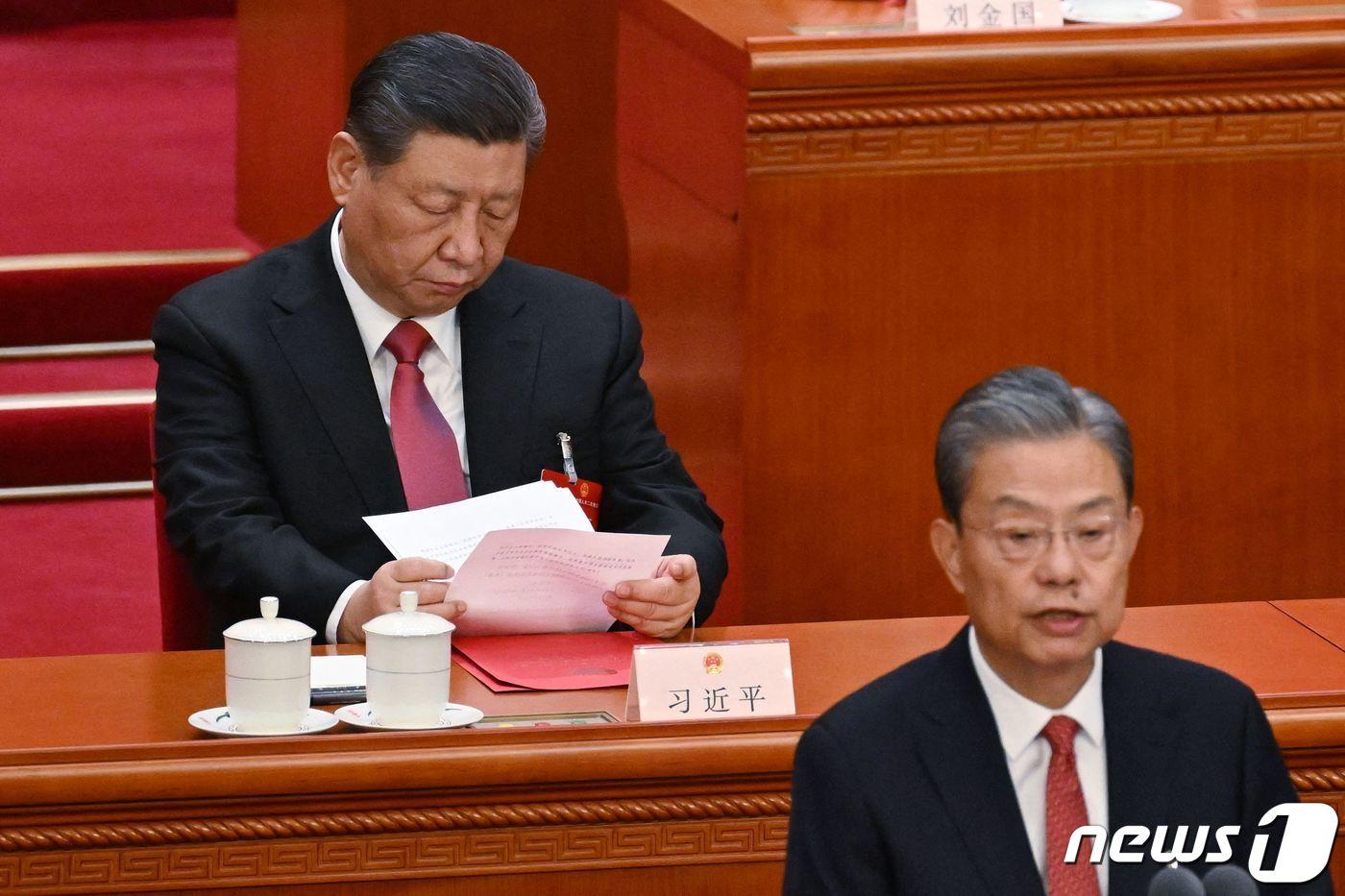 시진핑 중국 국가주석이 11일 (현지시간) 베이징 인민대회당에서 열린 전국인민대표대회(전인대) 폐막식서 자오러지 전인대 상무위원장의 연설 중 보고서를 보고 있다. 2024. 3. 12 ⓒ AFP=뉴스1 ⓒ News1 우동명 기자