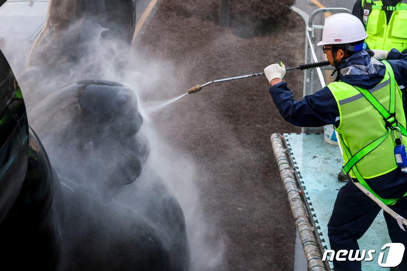 본문 이미지 - 송파구 관계자들이 서울 송파구 올림픽로에 설치된 올림픽 상징 역도 조형물을 고압 세척기를 이용해 물 청소를 하고 있다.  (공동취재) 2024.3.13/뉴스1 ⓒ News1 신웅수 기자