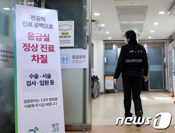 본문 이미지 - 의대 증원에 반발한 전공의 집단 이탈 사태가 4주차로 접어든 11일 경남 양산시 물금읍 양산부산대병원 응급실에 설치된 전공의 진료 공백으로 응급실 정상 진료 차질을 알리는 안내판 앞으로 119구급대원이 지나가고 있다. 정부는 이날부터 4주 동안 군의관 20명과 공중보건의 138명 등 모두 158명을 병원 20곳에 파견해 비상진료체계를 강화한다고 밝혔다. 2024.3.11 /뉴스1 윤일지 기자