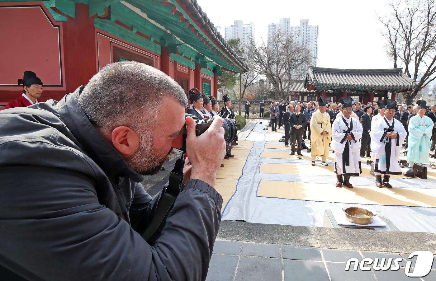 본문 이미지 - 대구 중구 대구향교를 찾은 스페인 관광객이 공기(孔紀) 2575년 춘계 석전대제를 촬영하고 있다. 2024.3.14 ⓒ 뉴스1 