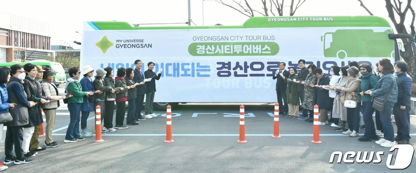 본문 이미지 - 14일 경산시티투어 오픈식에서 조현일 시장 등 내빈과 탑승객들이 오픈 퍼포먼스를 하고 있다. 10월까지 운영하는 경산 시티투어는 둘째 주 목요일 갓바위 일원을 돌아보는' 소원성취 코스'와 넷째 주 토요일 반곡지 일원을 돌아보는 '삼성현 명품 투어'로 구성됐다. (경산시 제공) 2024.3.14/뉴스1 ⓒ News1 정우용 기자