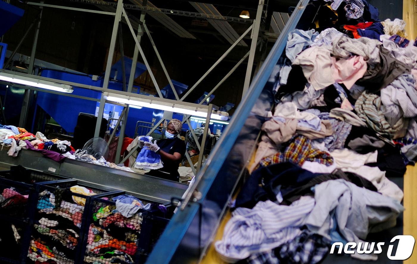 지난해 8월 스페인 북동부 카탈루냐의 산트 에스테베 세스로비레스에 위치한 공장에서 말리 출신 노동자 삼바디에(28)가 버려진 의류 중 중고시장에 내놓을 만한 것들을 선별하고 있다<자료사진>. 2023.8.1. ⓒ 로이터=뉴스1 ⓒ News1 김성식 기자
