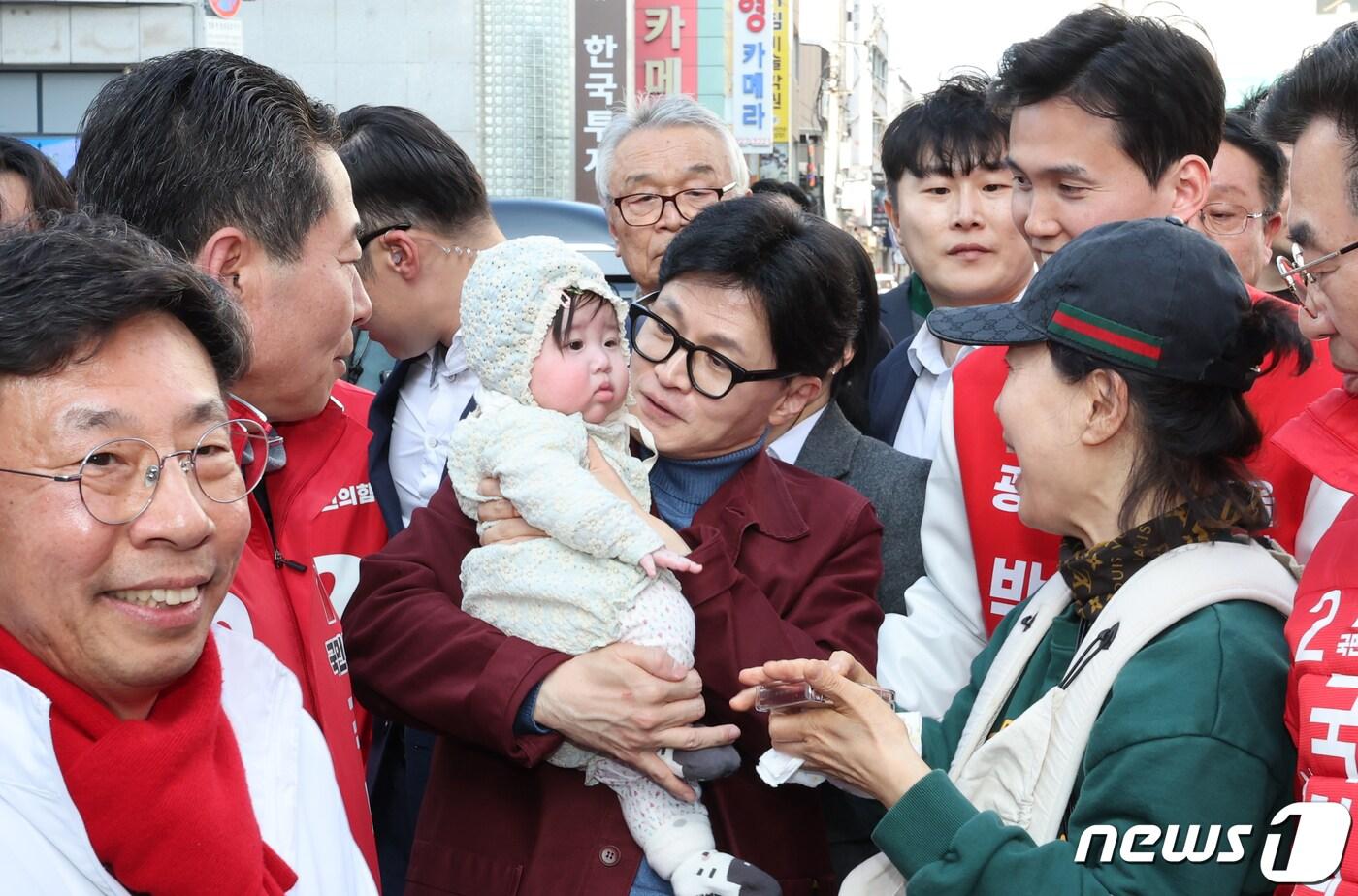 본문 이미지 - 한동훈 국민의힘 비상대책위원장이 15일 광주 동구 충장로에서 아이를 안고 기념 촬영을 하고 있다. 2024.3.15/뉴스1 ⓒ News1 김태성 기자