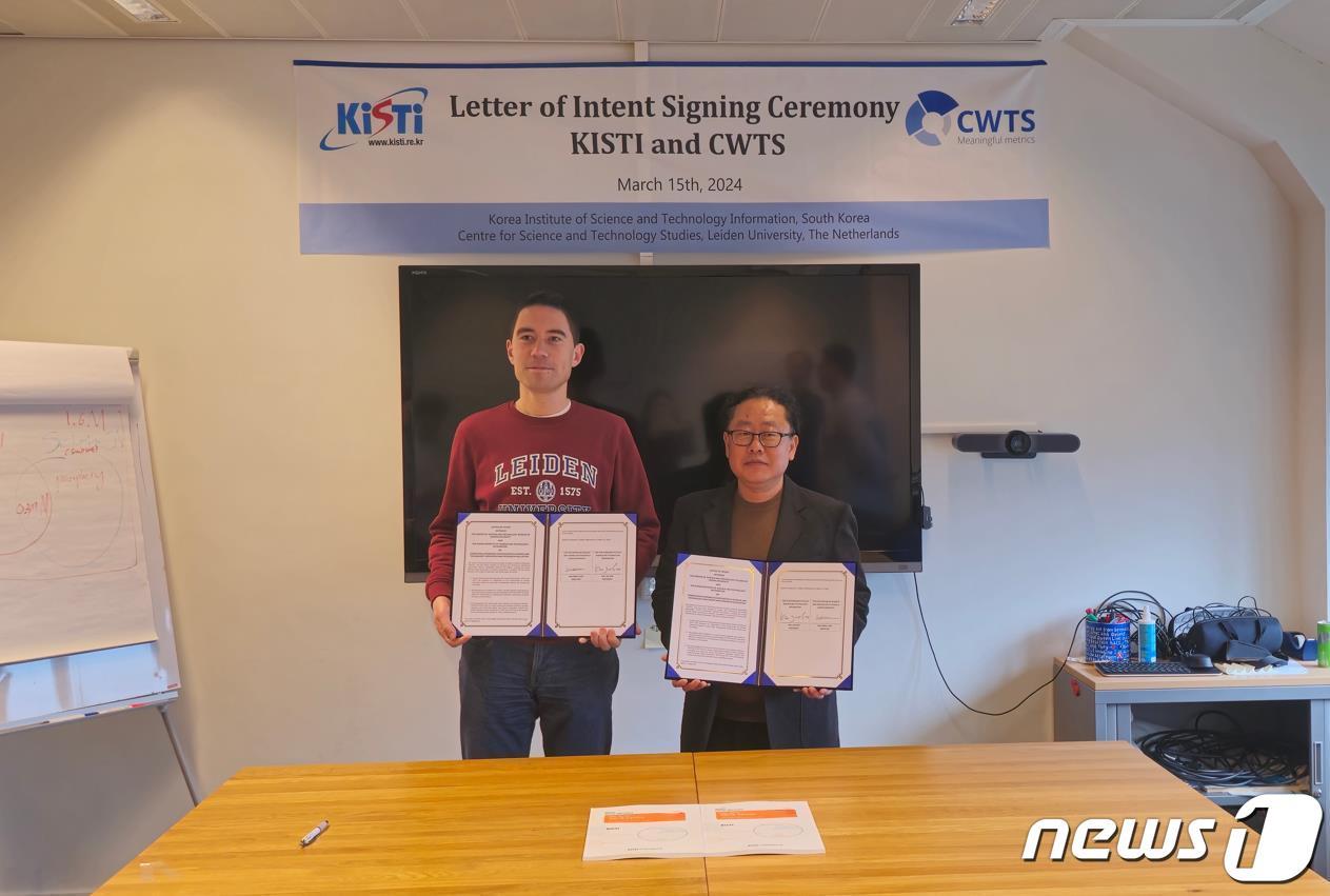 본문 이미지 - 왈트만 네덜란드 라이덴대학교 과학기술학연구소장(왼쪽)과 박진서 KISTI 글로벌R&D분석센터장이 협력의향서 체결한 뒤 기념촬영을 하고 있다. (과학기술정보연 제공)/뉴스1