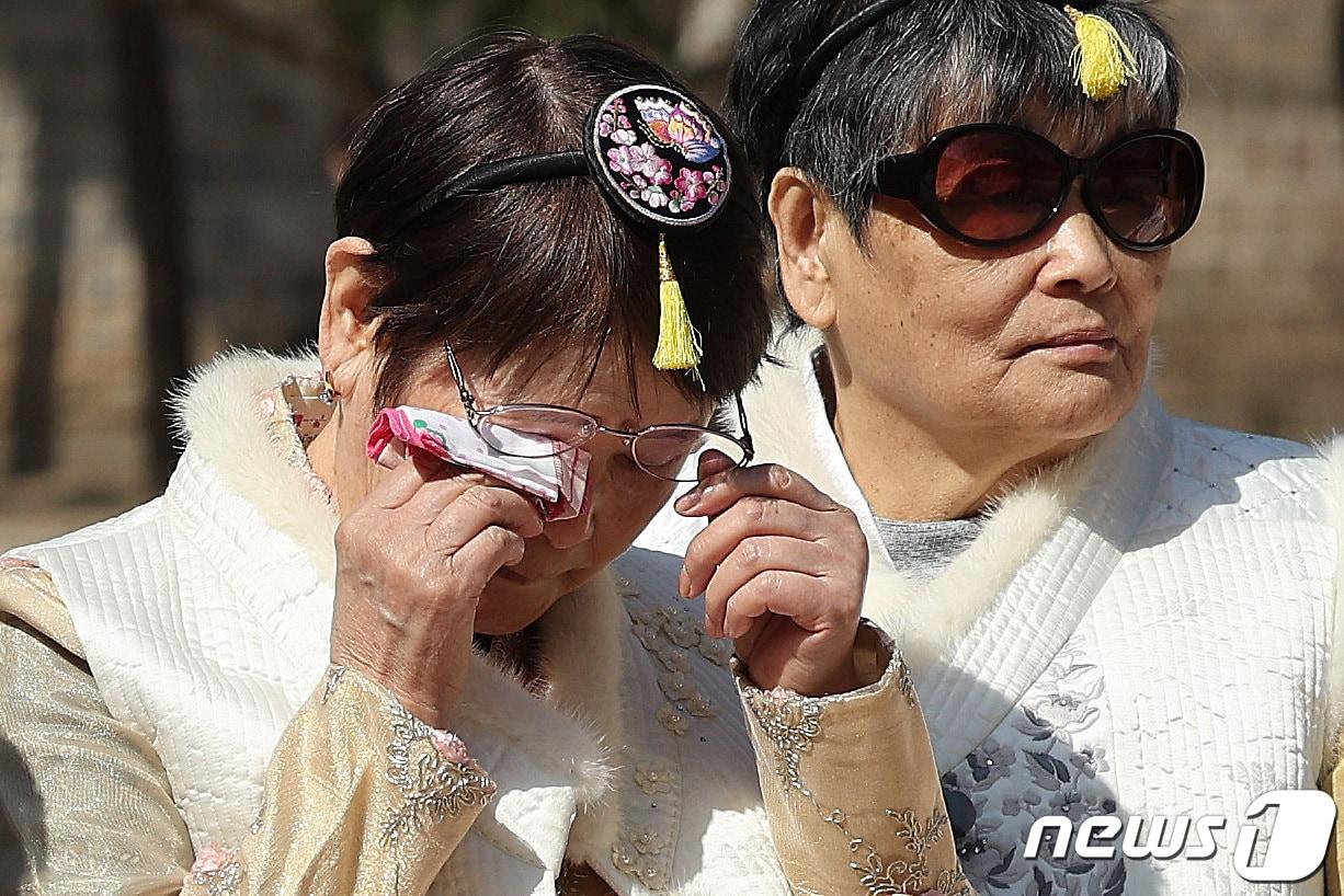 본문 이미지 - 한복을 입은 사할린 동포가 18일 서울 경복궁에서 기념촬영 중 감격의 눈물을 닦고 있다.  2024.3.18/뉴스1 ⓒ News1 박지혜 기자
