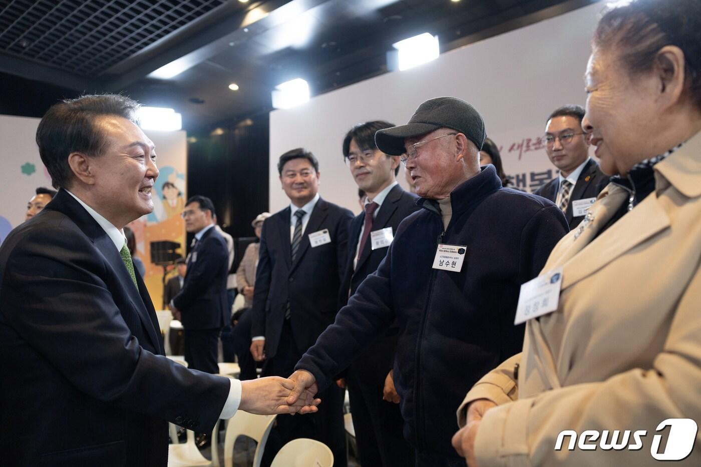 본문 이미지 - 윤석열 대통령이 21일 강원 원주시 건강보험심사평가원에서 ‘건강하고 행복한 노후’를 주제로 열린 22번째 국민과 함께하는 민생토론회에서 노인맞춤돌봄서비스 보호자 남수현 씨와 악수하고 있다. (대통령실 제공) 2024.3.21/뉴스1 ⓒ News1 안은나 기자