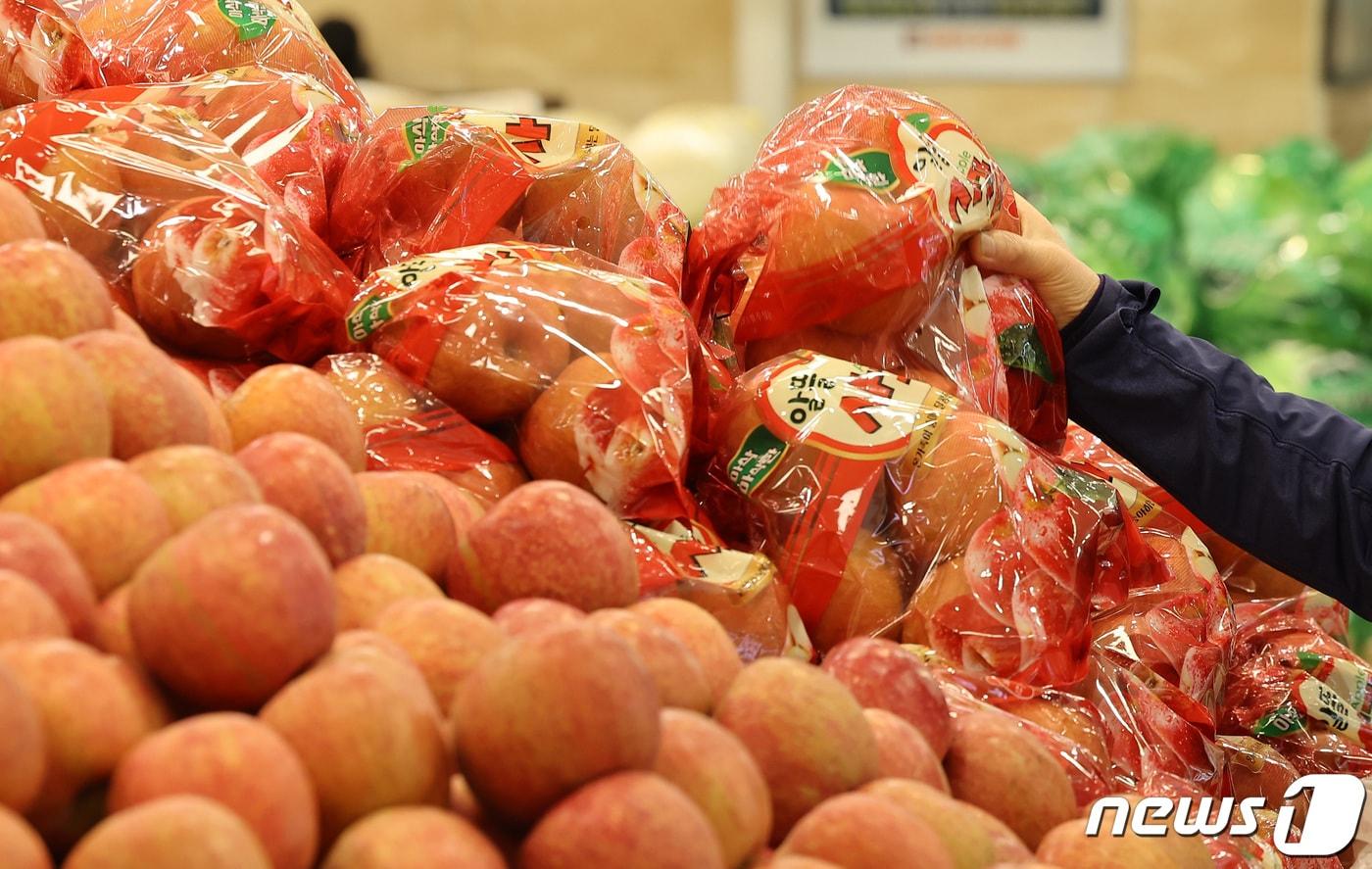 본문 이미지 - 사과와 배 소매가격이 농축산물 물가 안정을 위한 정부의 대규모 자금 투입 이후 10% 넘게 하락했다. 24일 한국농수산식품유통공사(aT) 농산물유통정보에 따르면 22일 기준으로 사과(후지·상품) 10개 소매가격은 2만4천250원으로 일주일 전인 15일보다 11.6% 내렸다. 사진은 이날 서울 시내 한 마트에서 한 시민이 사과를 구매하고 있다. 2024.3.24/뉴스1 ⓒ News1 김성진 기자