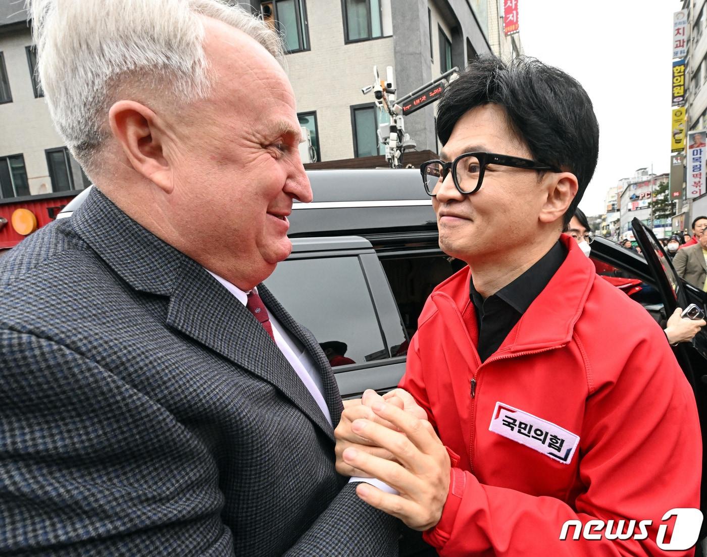 본문 이미지 - 한동훈 국민의힘 총괄선대위원장과 인요한 국민의미래 선거대책위원장이 25일 서울 신당동 떡볶이타운 거리에서 만나 인사를 나누고 있다. (공동취재) 2024.3.25/뉴스1 ⓒ News1 임세영 기자
