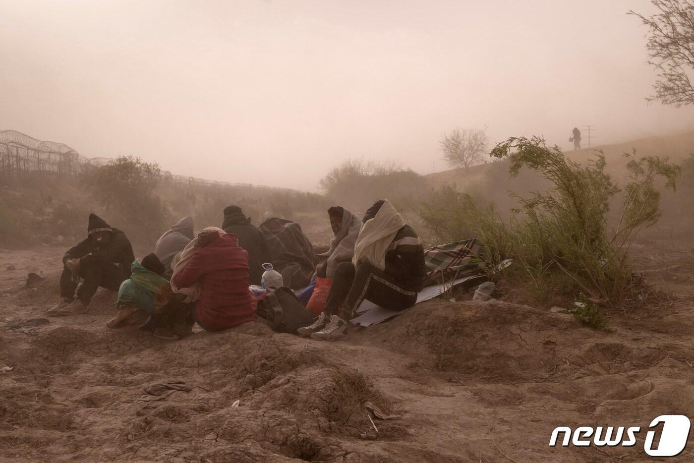24일&#40;현지시간&#41; 미국 텍사스주 엘 파소에서 이민자들이 미국으로 들어가는 입구를 찾으려 강한 바람과 먼지를 견디고 있다. 2024.03.24 ⓒ 로이터=뉴스1 ⓒ News1 정지윤 기자