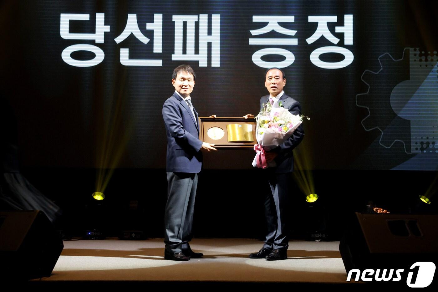 본문 이미지 - 박명진 김해상의 전 회장(왼쪽)이 노은식 신임회장에게 당선패를 증정하고 있다.(김해상의 제공)