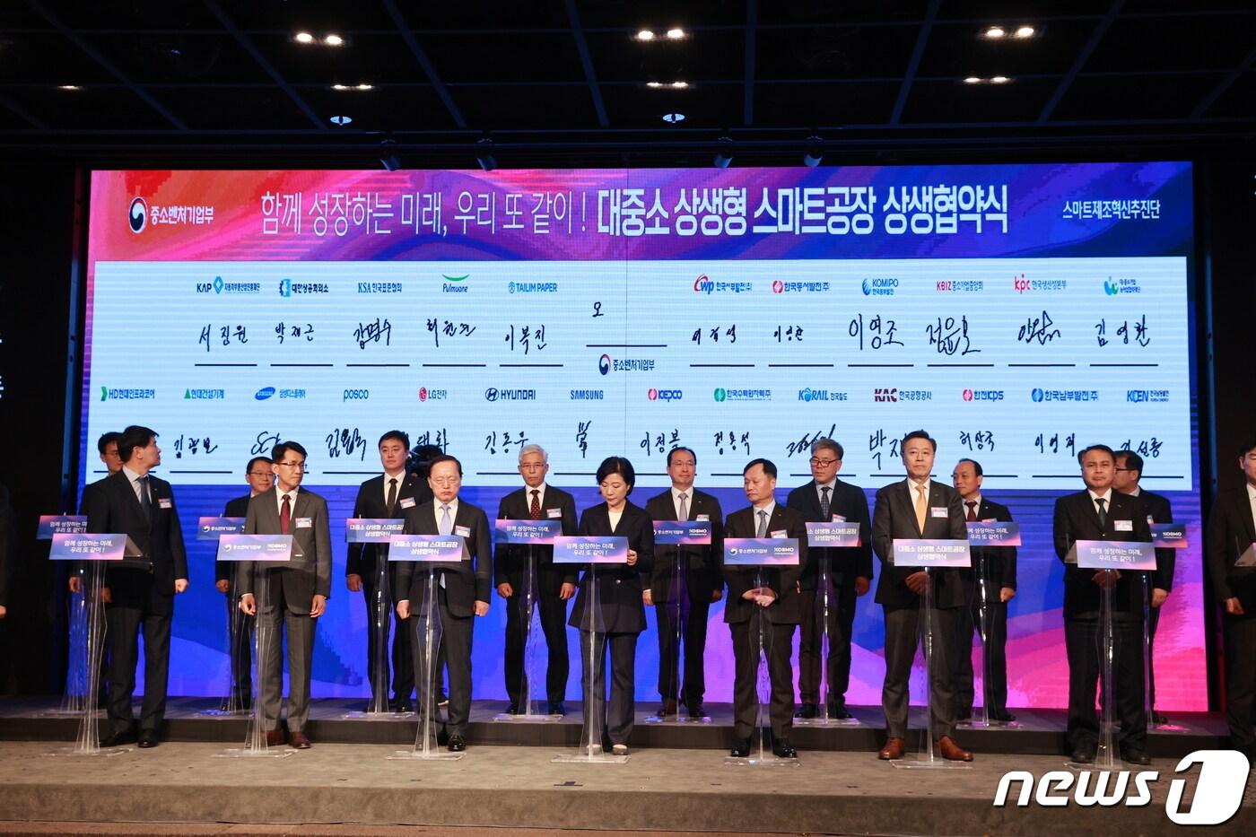 본문 이미지 - 오영주 중소벤처기업부 장관(앞줄 가운데)이 26일 서울 영등포구 중소기업중앙회에서 열린 '대중소 상생형 스마트공장 상생협약식'에서 참여기업과 '윈윈(Win-Win)' 비전선언문 작성 퍼포먼스를 하고있다. (중기부 제공)