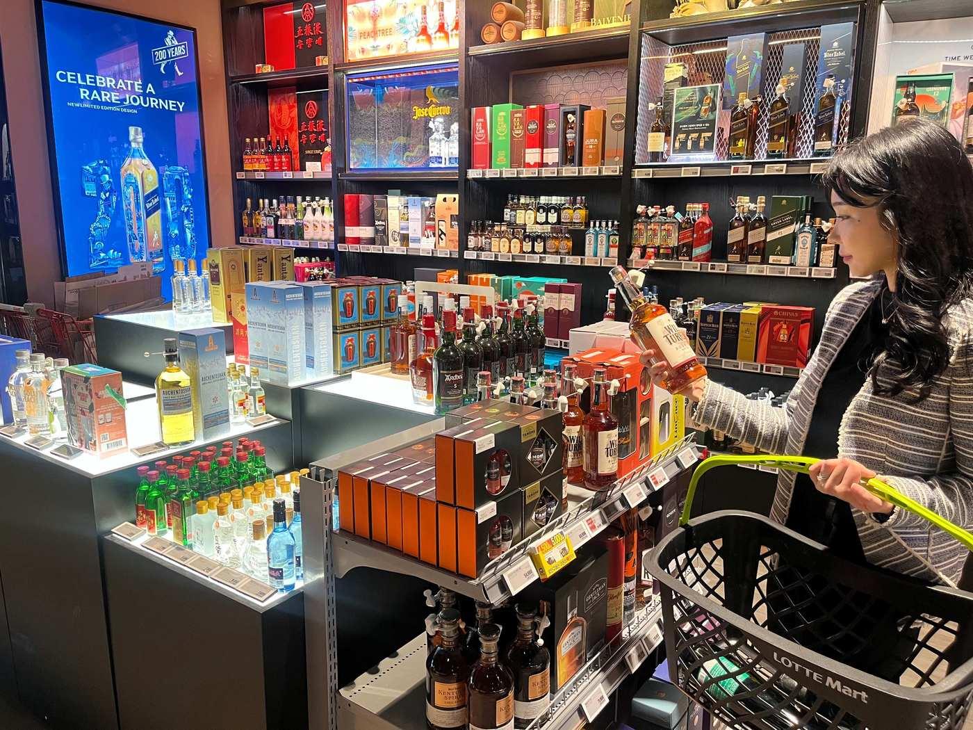 본문 이미지 - 롯데마트 월드타워점 주류매장에서 위스키 쇼핑을 하는 고객(롯데쇼핑 제공)