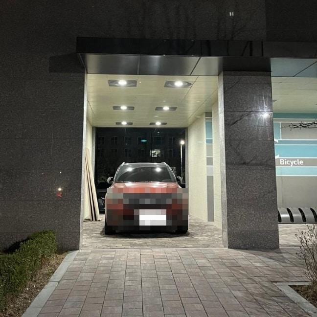 본문 이미지 - 필로티 구조 아파트 통행로에 차량 한 대가 주차돼 있다. 온라인 커뮤니티 갈무리