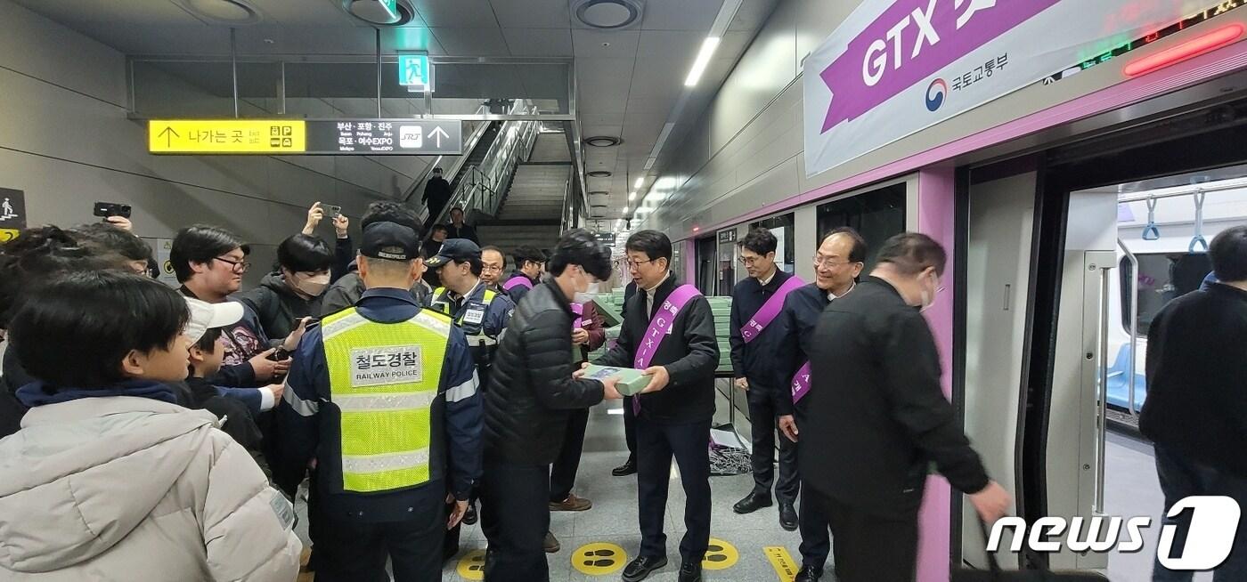 본문 이미지 - 박상우 국토교통부 장관이 30일 화성시 동탄역에서 GTX 첫 탑승객에게 기념품을 전달하고 있다. 2024.3.30/뉴스1 ⓒ News1 황보준엽 기자