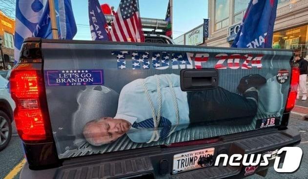 본문 이미지 - 바이든 대통령이 손발이 묶인채 피랍되는 듯한 이미지.  픽업트럭 뒤에 붙어있다. - 유튜브 갈무리