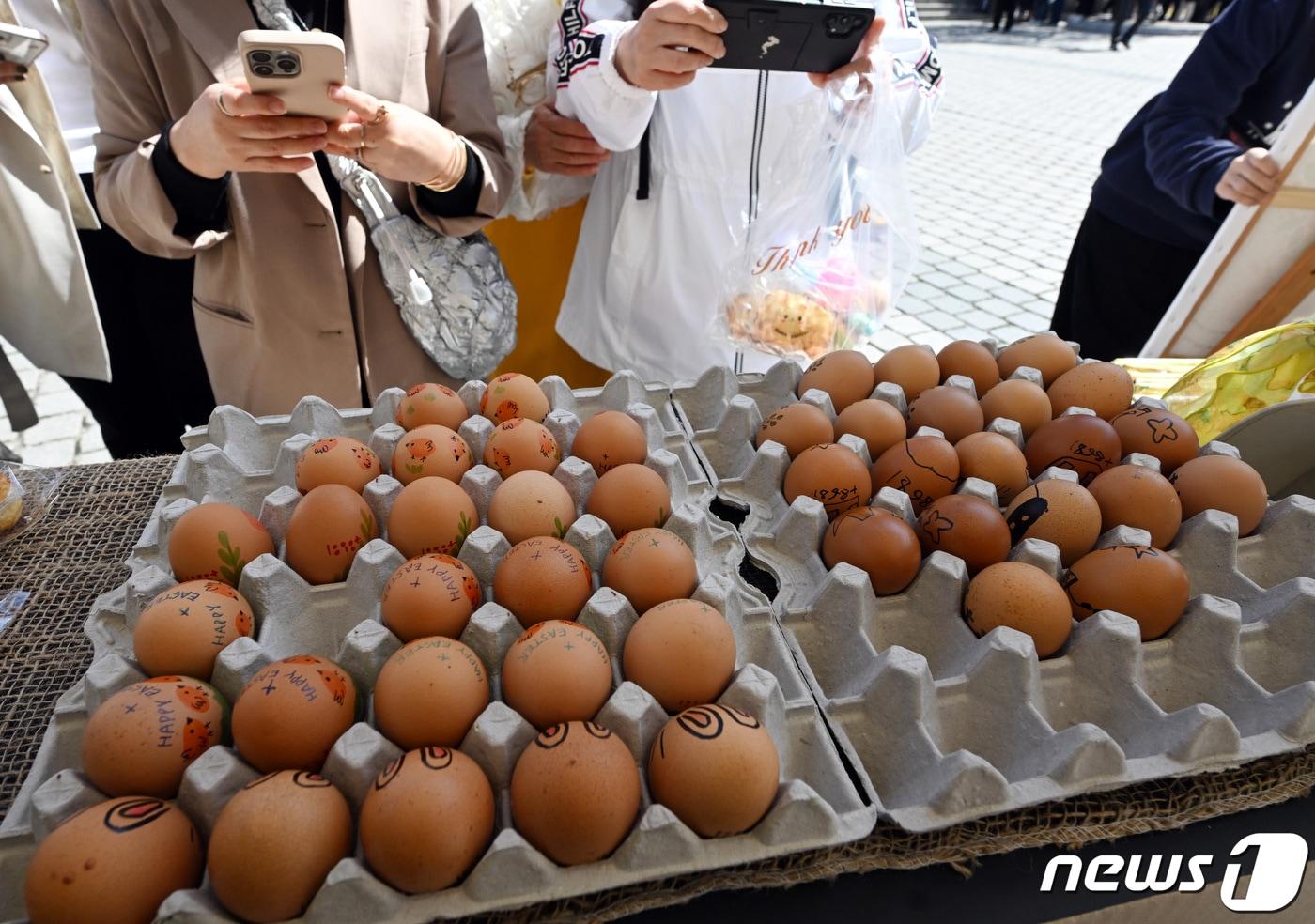 본문 이미지 - 주님 부활대축일 낮미사가 열린 31일 서울 중구 명동성당에서 신자들이 부활절 달걀을 스마트폰에 담고 있다. 2024.3.31/뉴스1 ⓒ News1 사진공동취재단