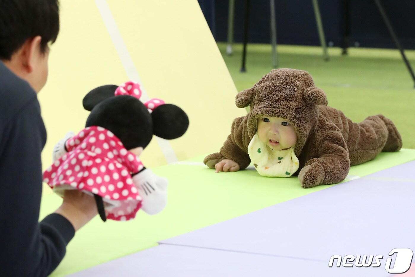 7일 대구 북구 엑스코에서 개막한 '제39회 대구베이비&키즈페어(대구베키)'의 부대행사로 열린 생후 12개월 이하 아기들의 경주 '컴 온 베이비(come on baby)' 이벤트에 출전한 아기들이 아빠·엄마의 손짓을 바라보며 결승선을 향해 다가가고 있다. 2024.3.7/뉴스1 ⓒ News1 공정식 기자