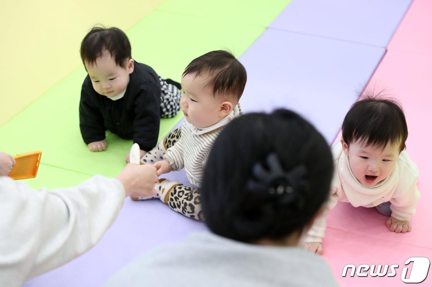 7일 대구 북구 엑스코에서 개막한 '제39회 대구베이비&키즈페어(대구베키)'의 부대행사로 열린 생후 12개월 이하 아기들의 경주 '컴 온 베이비(come on baby)' 이벤트에 출전한 아기들이 아빠·엄마의 손짓을 바라보며 결승선을 향해 다가가고 있다. 2024.3.7/뉴스1 ⓒ News1 공정식 기자