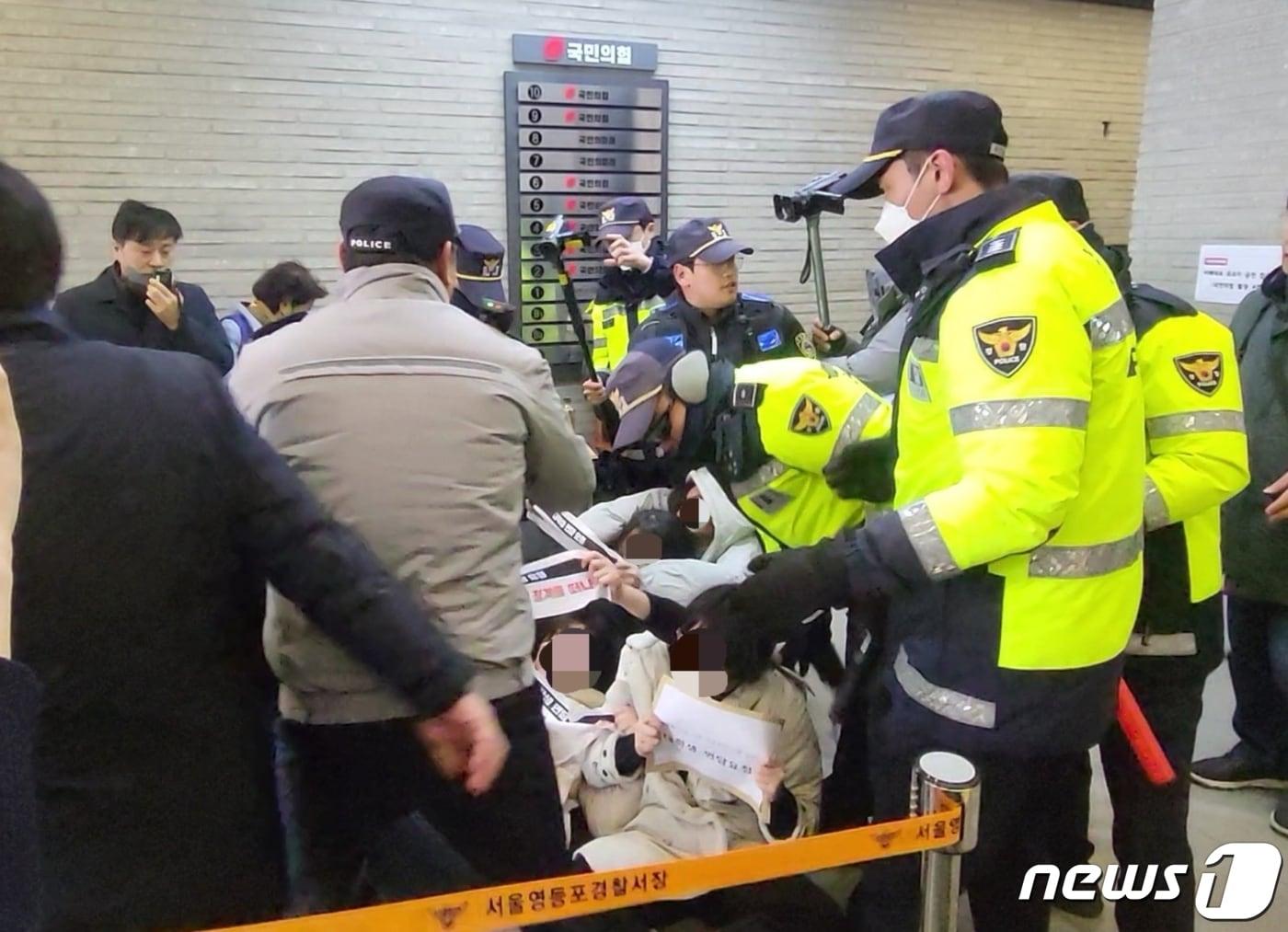 본문 이미지 - 한국대학생진보연합이 10일 국민의힘 당사에 난입해 성일종 국민의힘 의원의 사퇴를 요구하다 경찰에 끌려나가는 모습. ⓒ News1 신윤하 기자