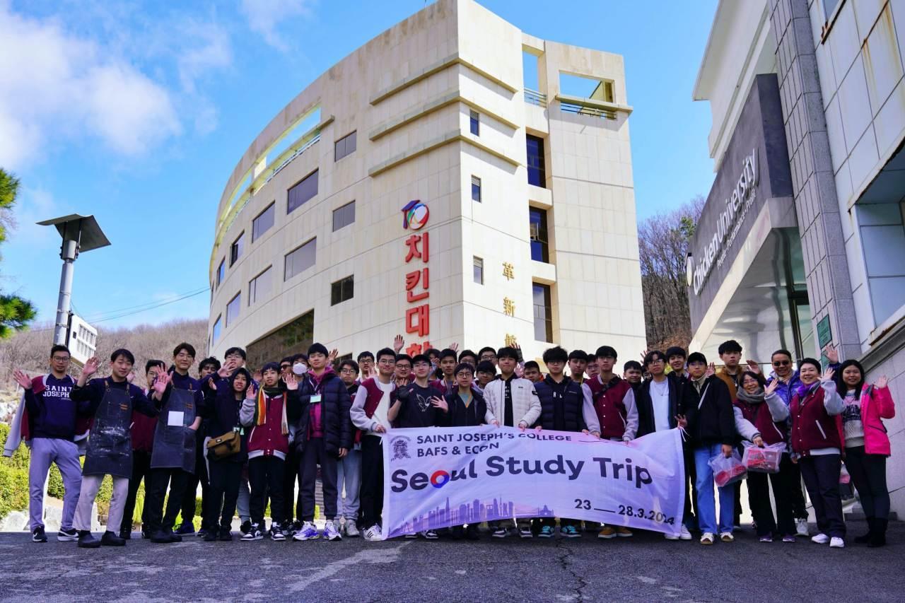 본문 이미지 - 치킨대학 치킨캠프에 참여한 홍콩 세인트 조셉 칼리지(St Joseph's College) 고등학교 학생과 교사가 경기도 이천시에 소재한 치킨대학 앞에서 기념사진을 촬영하고 있다.(제너시스BBQ 그룹 제공)