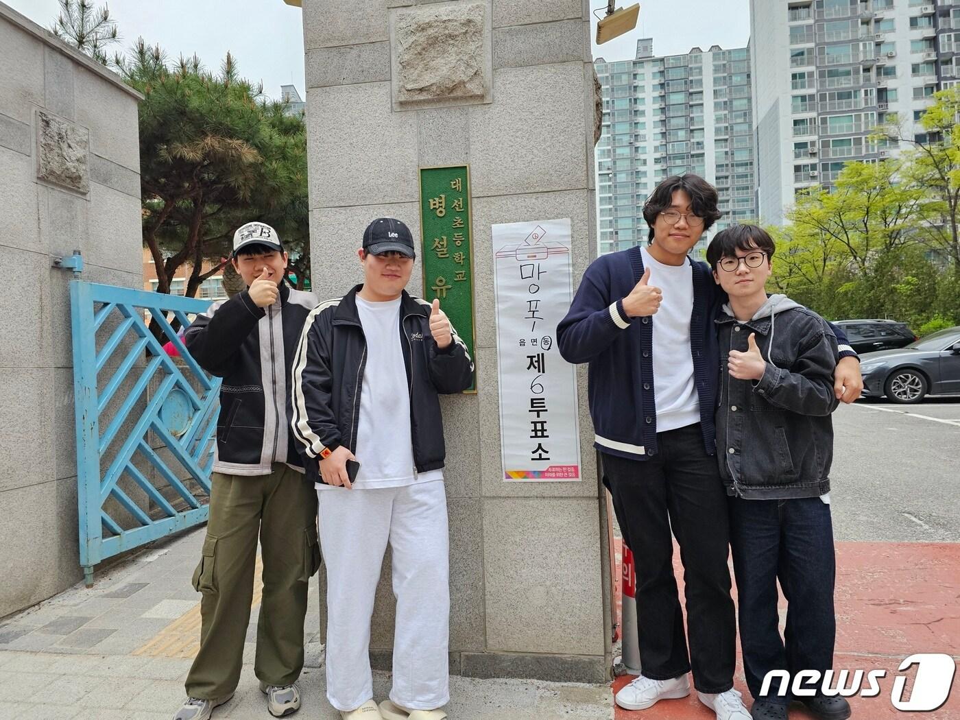 본문 이미지 -  제22대 국회의원선거(4·10 총선) 본 투표일인 10일 오전 6시 25분쯤 경기 수원시 영통구 망포1동 제5투표소 대선초등학교에서 투표를 마친 김세영(19)씨와 신희수·윤형주·최원혁(18)씨가 기념촬영을 하고 있다. 2024.4.10/뉴스1 ⓒ News1 김기현 기자 