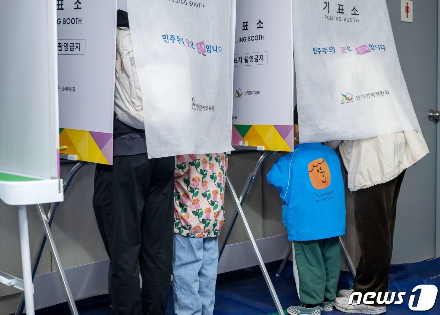 본문 이미지 - 제22대 국회의원 선거일인 10일 오전 부산 부산진구 신개금엘지아파트에 마련된 개금제3동 제8투표소에서 유권자인 부모를 따라온 아이들이 기표소 안을 들여다보고 있다. 2024.4.10/뉴스1 ⓒ News1 윤일지 기자