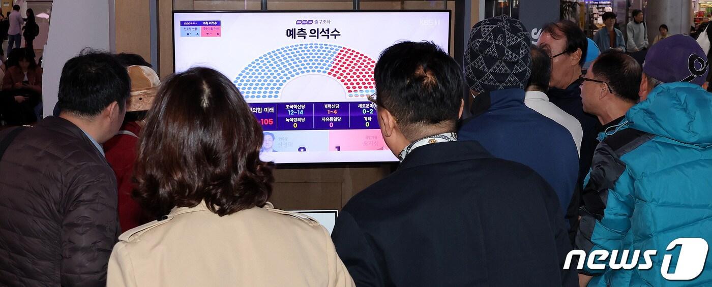 본문 이미지 - 10일 오후 서울 용산구 서울역 대합실에서 시민들이 제22대 국회의원선거 방송 3사 출구조사 결과 생중계를 지켜보고 있다. 2024.4.10/뉴스1 ⓒ News1 박지혜 기자