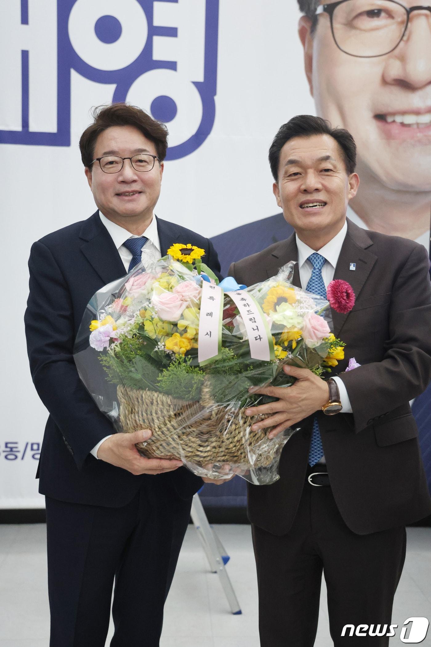 본문 이미지 - 제22대 국회의원 선거 경기 수원무에 출마한 염태영 더불어민주당 후보가 11일 오전 경기 수원시 권선구에 위치한 선거사무소에서 당선이 유력시 되자 이재준 수원시장에게 꽃을 받으며 기뻐하고 있다. 2024.4.11/뉴스1 ⓒ News1 경기사진공동취재단