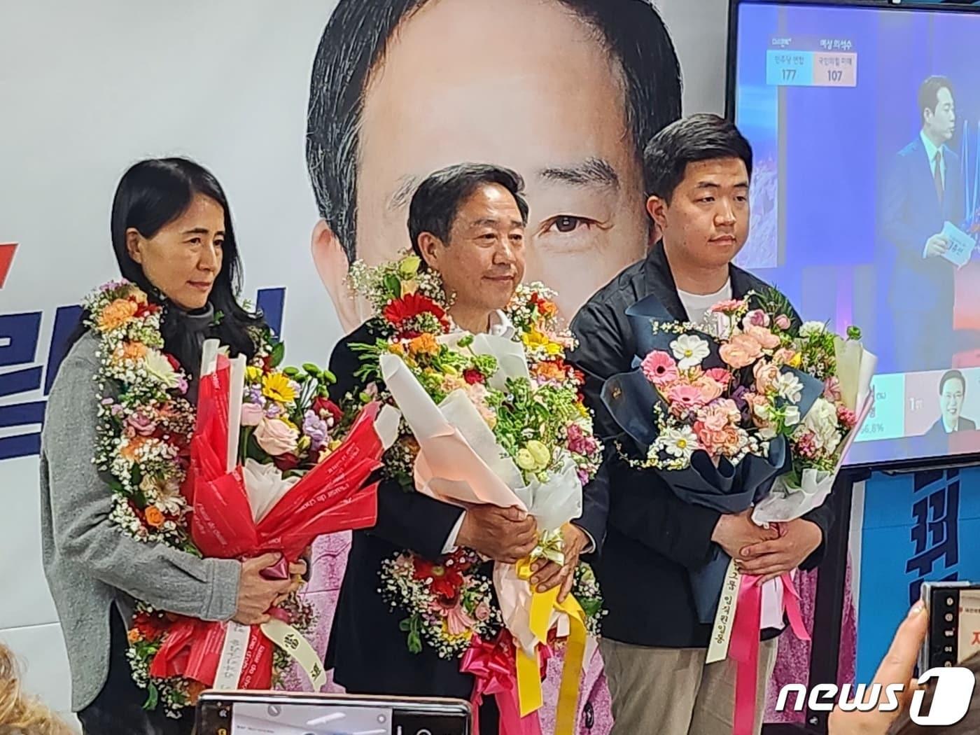 본문 이미지 - 강승규 후보가 당성이 확정되자 화환을 받고 기념촬영을 하고 다.(선거캠프 제공)/뉴스1