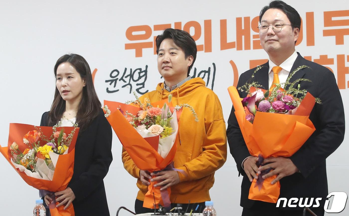 4·10 총선 경기 화성을에서 당선된 이준석 개혁신당 대표와 비례대표로 당선된 이주영·천하람 총괄선대위원장이 11일 오후 서울 여의도 국회에서 열린 개혁신당 중앙선거대책위원회 해단식에서 꽃다발을 들고 기념촬영을 하고 있다. 2024.4.11/뉴스1 ⓒ News1 임세영 기자