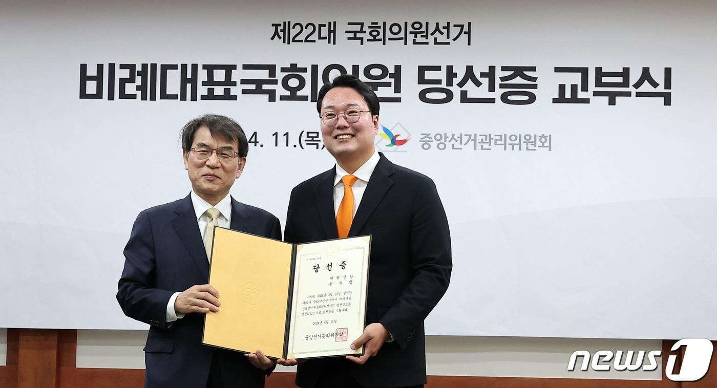 본문 이미지 - 천하람 개혁신당 비례대표 당선인이 11일 경기도 과천 중앙선거관리위원회에서 열린 비례대표국회의원 당선인 결정 및 당선증 교부식에서 당선증을 받은 후 노태악 중앙선거관리위원장과 기념 촬영을 하고 있다. 2024.4.11/뉴스1 ⓒ News1 김성진 기자