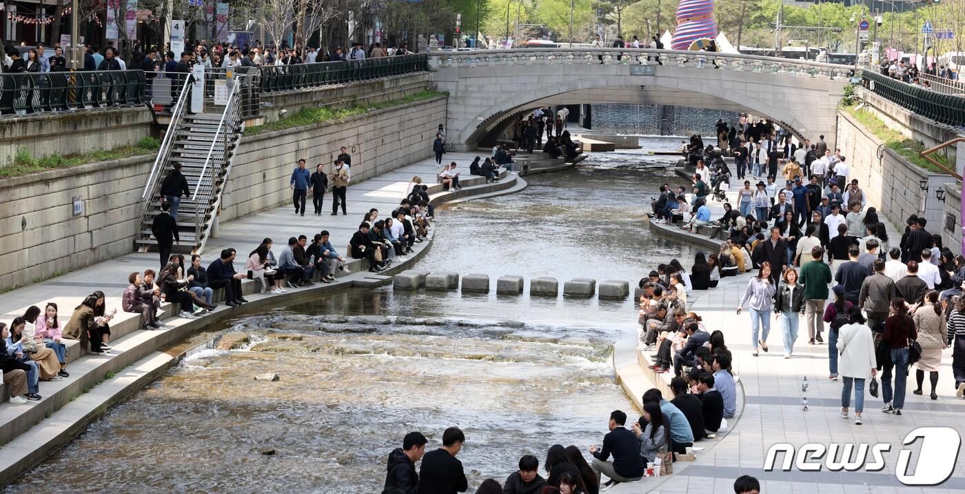 본문 이미지 - 화창한 봄 날씨를 보인 12일 서울 청계천에서 점심식사를 마친 직장인들이 휴식을 취하며 봄날의 정취를 만끽하고 있다. 2024.4.12/뉴스1 ⓒ News1 김명섭 기자