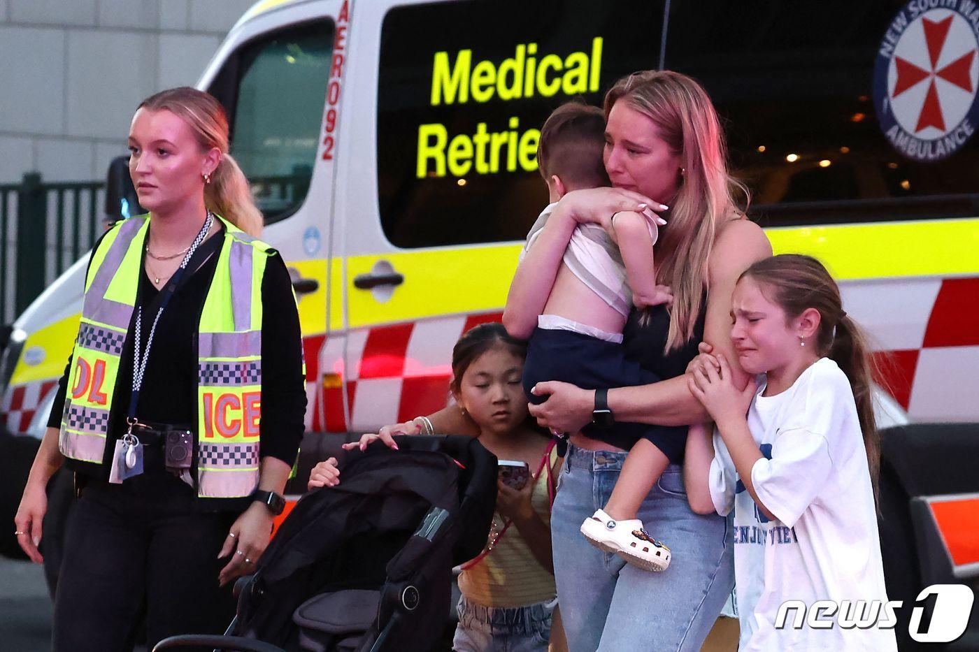 13일(현지시간) 호주 시드니 번화가에서 무차별 흉기 난동을 피해 쇼핑몰에서 대피한 한 가족이 경찰의 안내를 받으며 이동하고 있다. 2024.04.13/ ⓒ AFP=뉴스1 ⓒ News1 권진영 기자