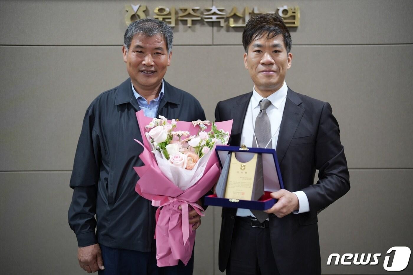 본문 이미지 - 신동훈 강원 원주축산업협동조합장이 15일 오전 조합 본점에서 지역 축산업 활성화를 도운 원주시청 공무원노동조합의 문성호 사무국장(오른쪽)에게 감사패를 전달했다. (원주시청 공무원노동조합 제공) 2024.4.15/뉴스1