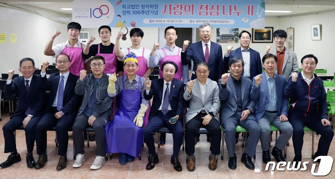 본문 이미지 - 학교법인 청석학원 창학 100주년 기념사업회 오영식 회장(앞줄 왼쪽 다섯번째)과 회원들이 19일 청주 중앙공원 YMCA 무료급식소에서 사랑의 점심 나누기 봉사활동을 펼친 뒤 기념촬영을 하고 있다.(청주대 제공)/뉴스1