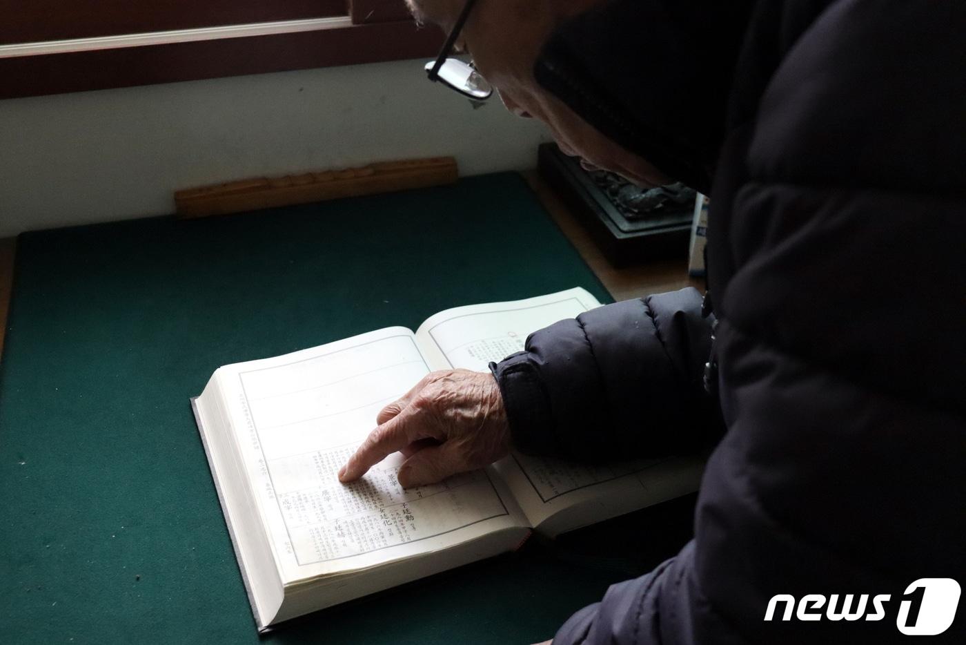 본문 이미지 - 국군포로 유가족 이강복 씨가 충남 서산의 자택에서 북한으로 끌려간 가족들의 이름이 적힌 족보를 들춰보고 있다. 2023.12.26/뉴스1 ⓒ News1 박동해 기자