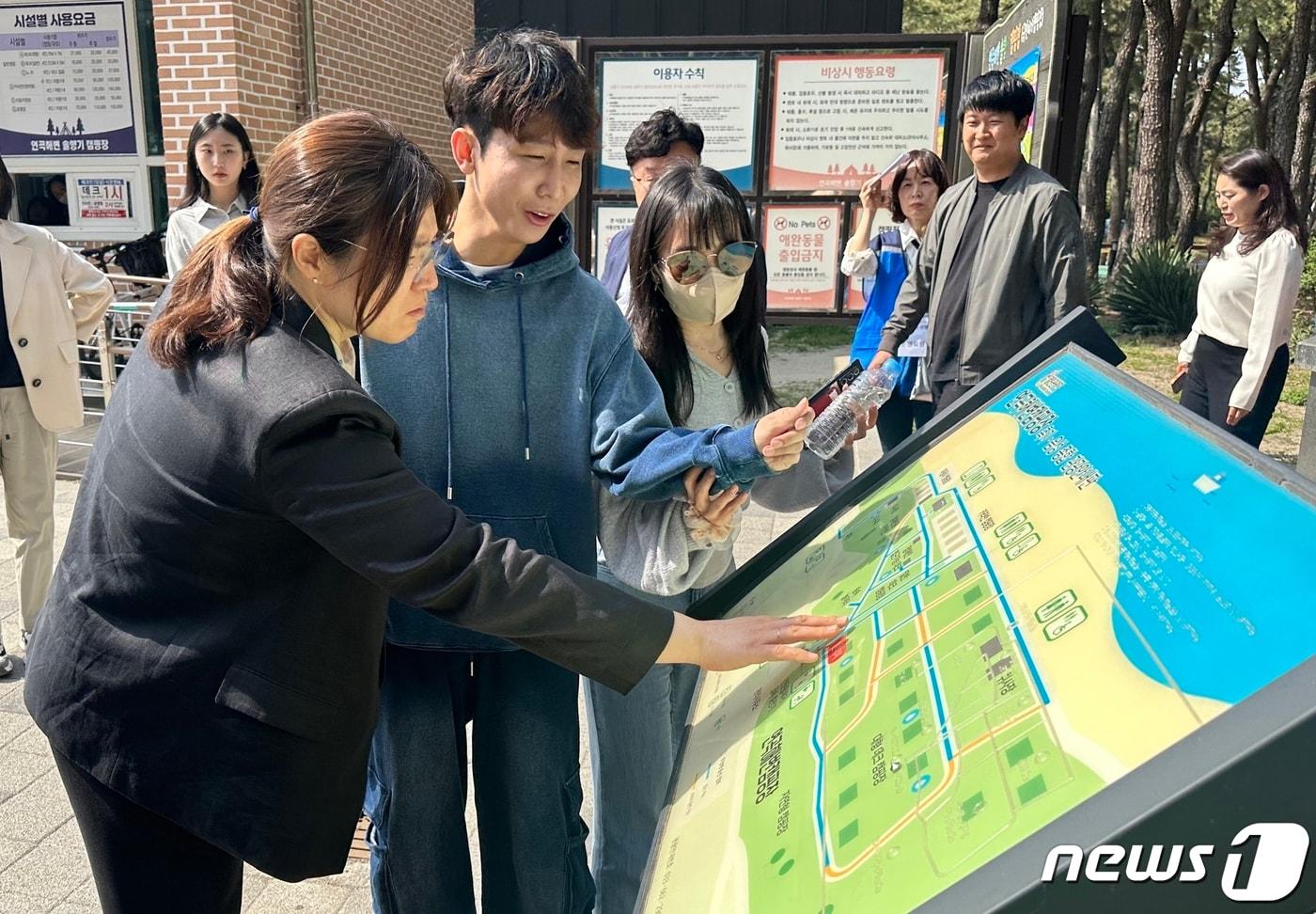 본문 이미지 - 장미란 문화체육관광부 제2차관이 시각장애 유튜브 창작자 '원샷한솔' 김한솔 씨와 연곡솔향캠핑장에서 점자 안내판을 직접 작동해보고 있다ⓒ News1 윤슬빈 기자