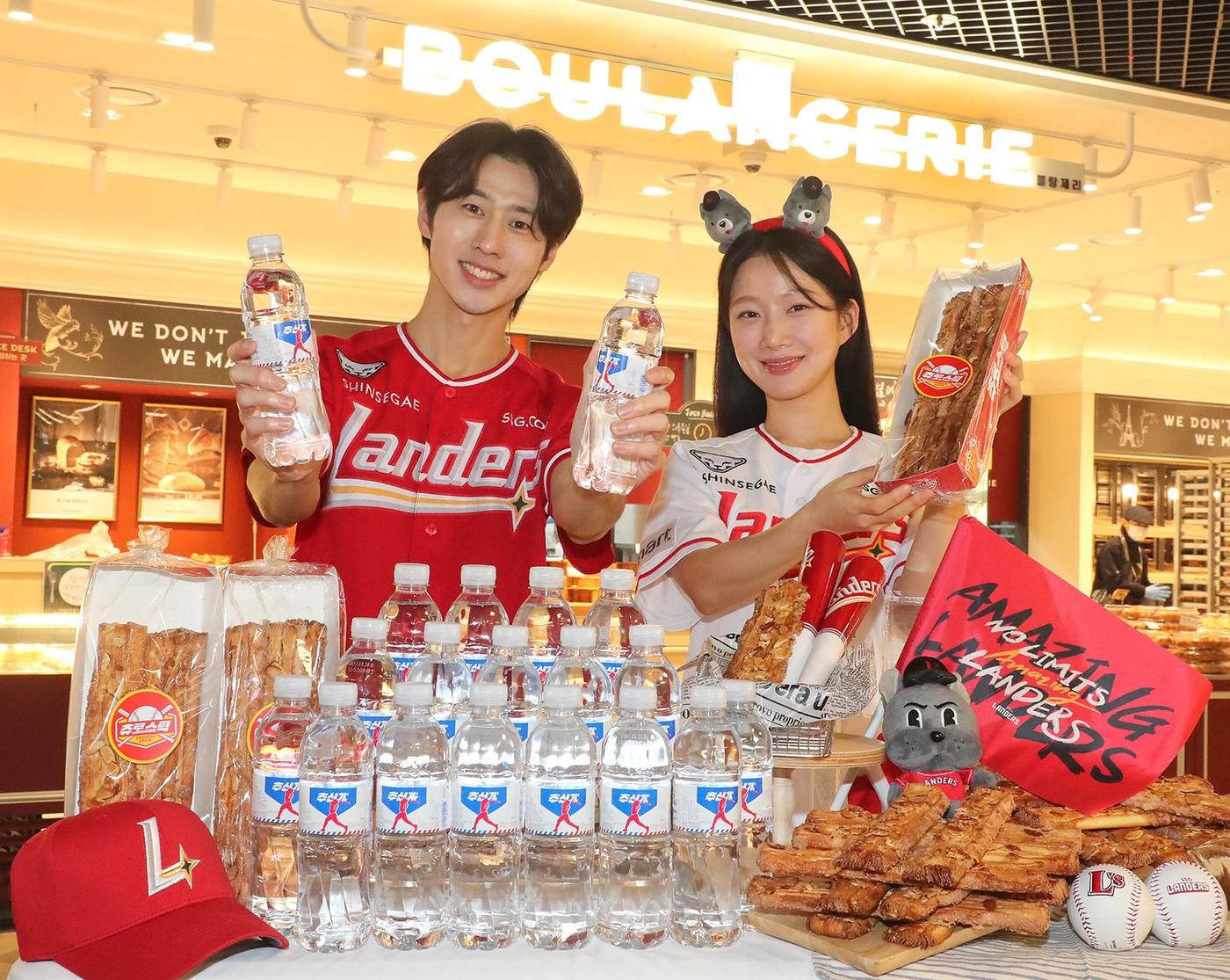 본문 이미지 - 2일 인천 연수구 이마트 연수점 내 블랑제리 매장에서 모델들이 신세계푸드가 24 시즌 판매를 시작한 ‘추신水’ 생수와 야구 응원 간식으로 선보인 ‘츄로스틱’을 소개하고 있다.(신세계푸드 제공)