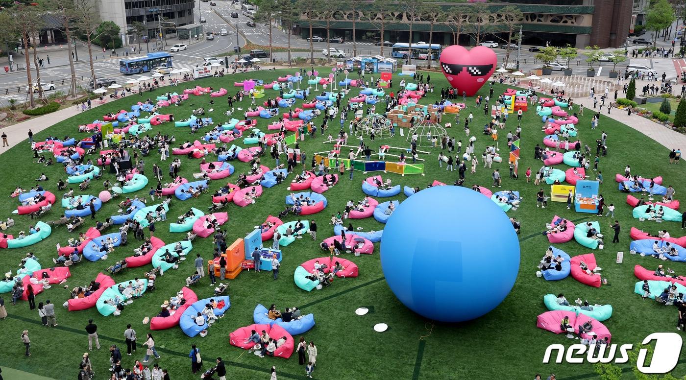 서울야외도서관 운영 첫 주말을 맞은 21일 오후 서울 중구 서울광장에 마련된 &#39;책읽는 서울광장&#39;을 찾은 시민들이 독서와 산책을 즐기고 있다.  2024.4.21/뉴스1 ⓒ News1 장수영 기자