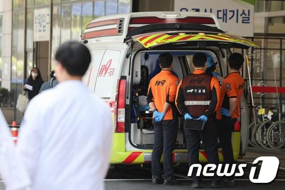 본문 이미지 - 정부의 의대 정원 확대에 반발하는 전공의를 비롯한 의료계의 집단행동이 이어지고 있는 18일 서울의 한 대학병원에서 응급대원들이 환자를 이송하고 있다. 2024. 4. 18/뉴스1 신웅수 기자