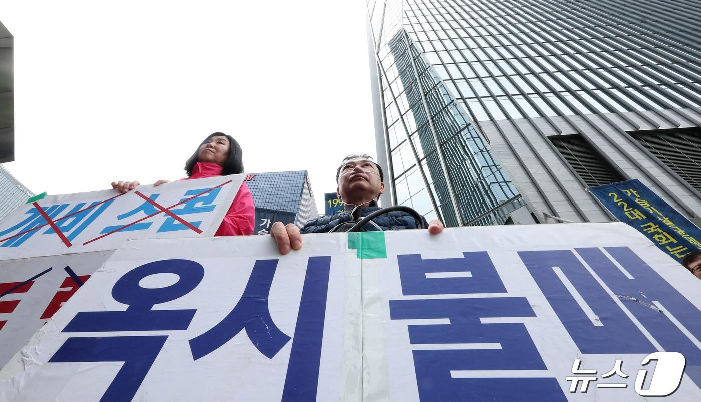 본문 이미지 - 가습기 살균제 참사 피해자 민수연 씨와 서영철 씨가 22일 서울 영등포구 여의도 옥시 사옥 앞에서 열린 '1853번째 가습기살균제 참사 피해자의 죽음' 기자회견에서 손피켓을 들고 자리하고 있다. 2024.4.22 ⓒ 뉴스1 김성진 기자
