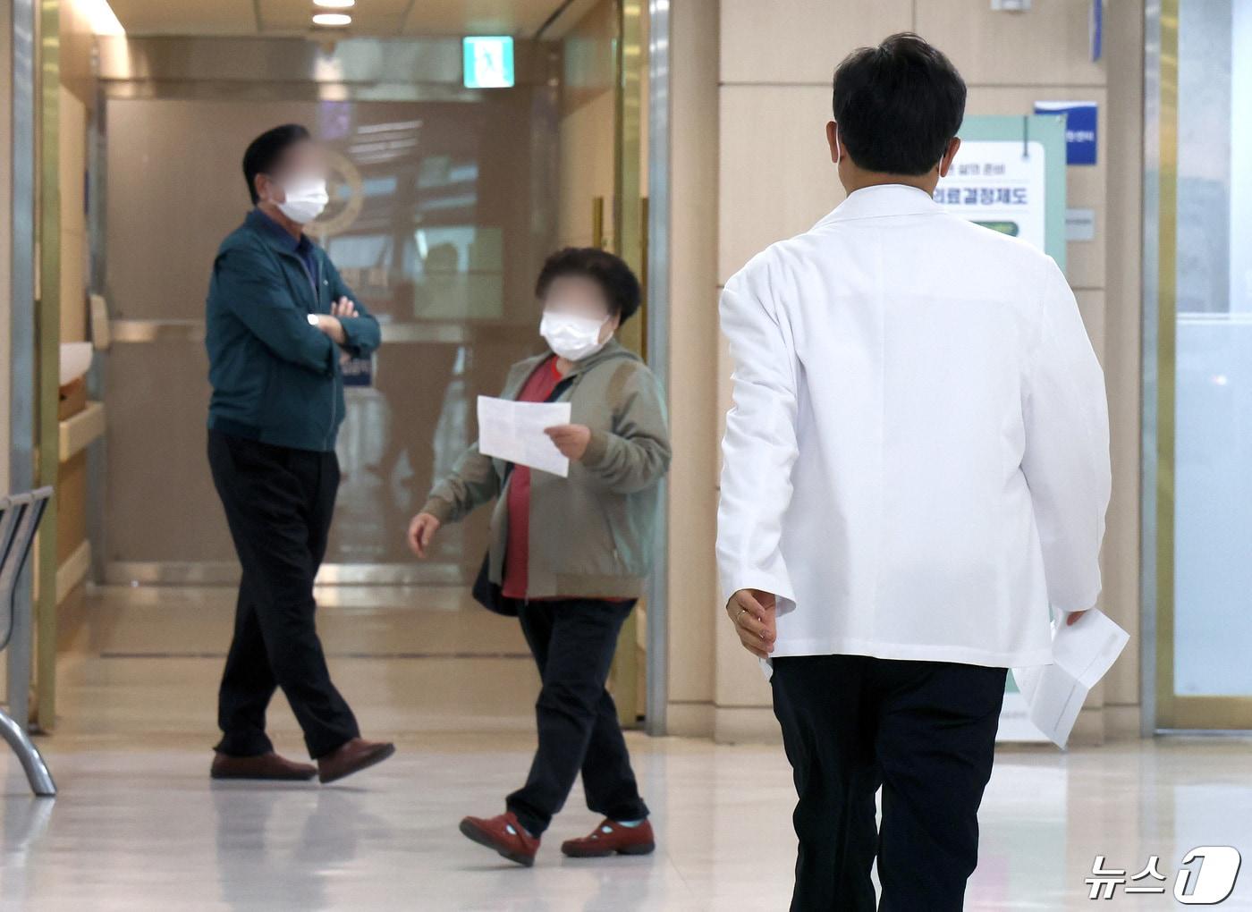 본문 이미지 - 정부의 의대 정원 확대에 반발하는 전공의를 비롯한 의료계의 집단행동이 이어지고 있는 23일 서울의 한 대학병원에서 의료진과 환자가 발걸음을 옮기고 있다. 2024.4.22/뉴스1 ⓒ News1 이동해 기자