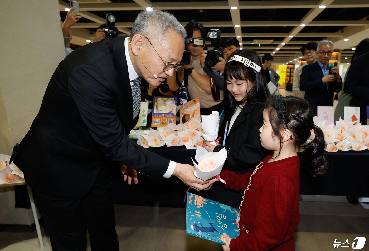 유인촌 문화체육관광부 장관이 23일 서울 종로구 세종문화회관에서 열린 세계 책의 날 '더 많은 책, 더 넓은 세계' 행사에서 어린이들에게 책과 꽃을 나눠주고 있다. 2024.4.23/뉴스1 ⓒ News1 안은나 기자